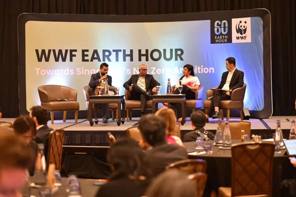 Panel discussion with four people seated on stage at WWF Earth Hour event about Singapore’s Net Zero Ambition.